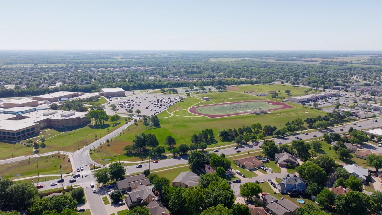 Aerial view of a large Derby school campus with a stadium and track