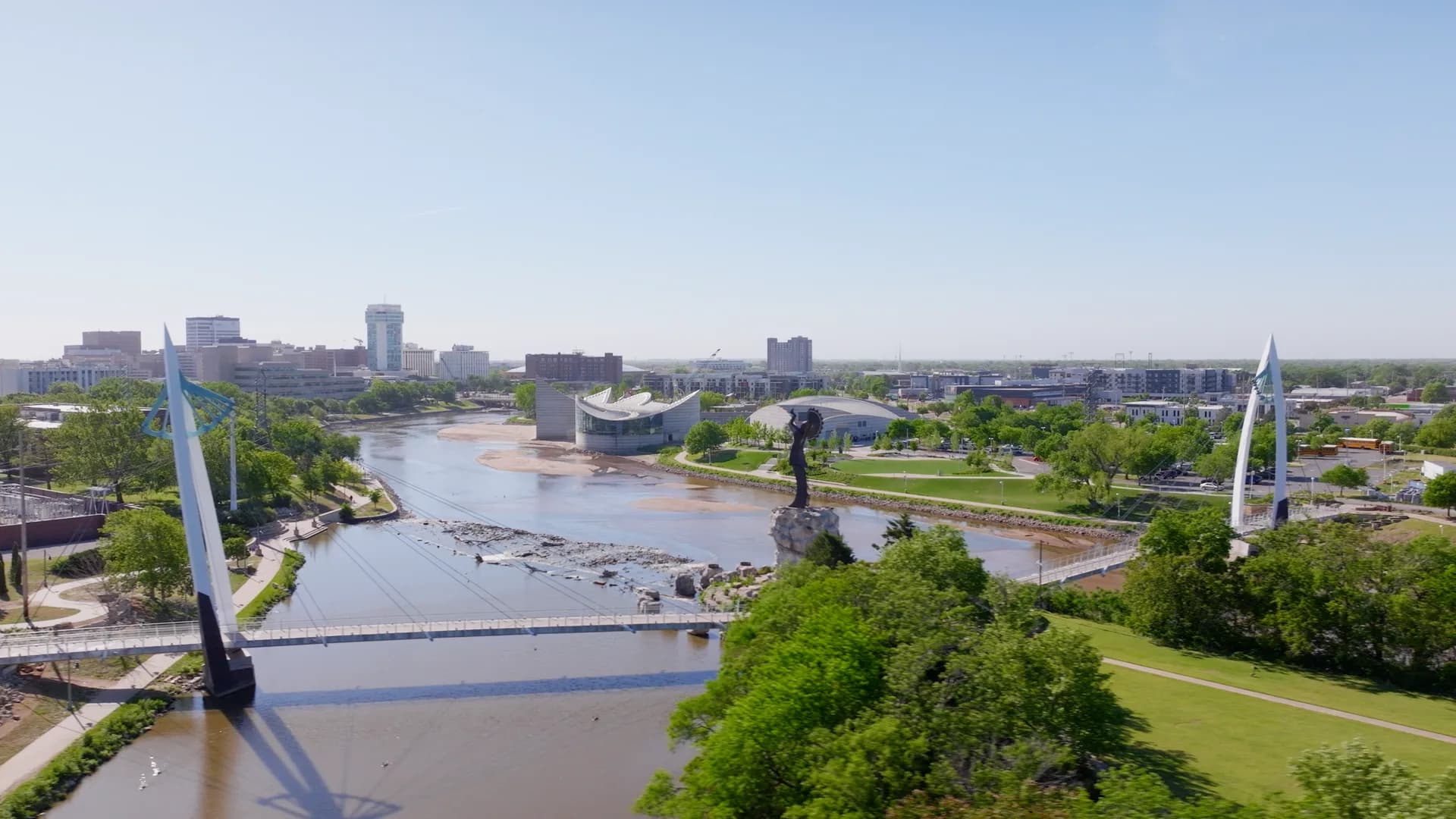 Keeper of the Plains and the Arkansas River with the downtown Wichita skyline behind it